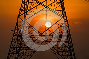 Silhouette of bird perched on high voltage post,High voltage tower sky sunset background