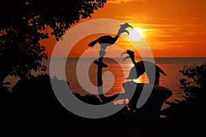 Silhouette of Birds Hornbill statue with trees and red sky sunset