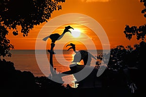 Silhouette of Birds Hornbill statue with trees and red sky sunset
