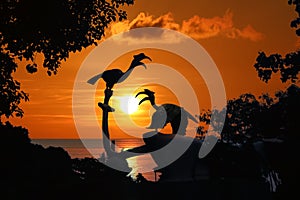 Silhouette of Birds Hornbill statue with trees and red sky sunset