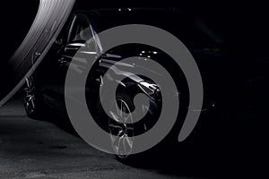 Silhouette of black sports car with headlights on black background