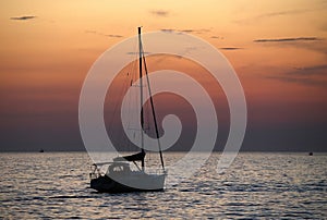 Silhouette of the boat against orange evening sky