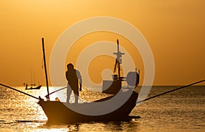 Silhouette of boat and fisherman sunset time