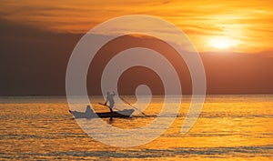 Silhouette of boat and fisherman sunset time