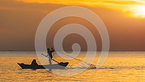 Silhouette of boat and fisherman sunset time