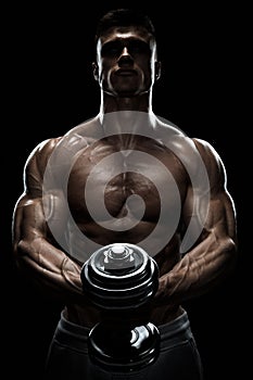 Silhouette of a bodybuilder pumping up muscles with dumbbell