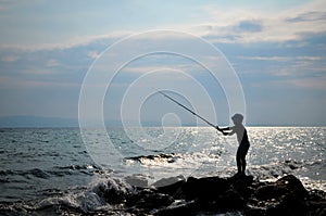 Silhouette of boy fishing