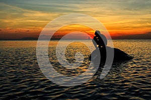 Silhouette of a boy fishing during sunset