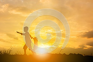 Silhouette of Boy and girl playing at sunset background, Happy children concept