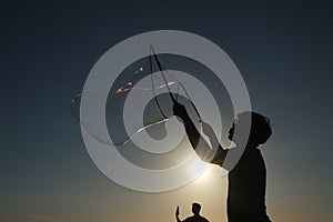 Silhouette boy playing with a bubble wand on the beach