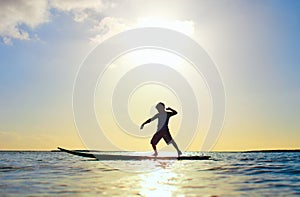 Silhouette of a boy on surfboard