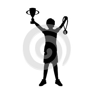 Silhouette boy winner of competition with cup and medal around his neck. Victory celebration.