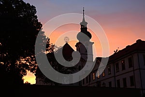 The silhouette of the Brevnov monastery in the setting sun. photo