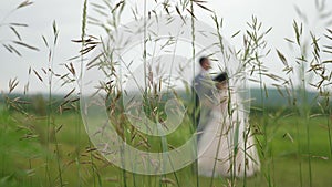Silhouette of a bride in a beautiful white dress and groom dancing on the meadow. teamwork of a loving couple. happy