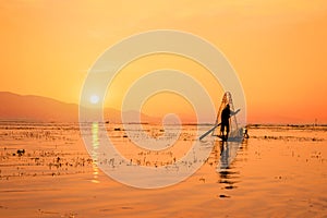 Silhouette of a Burmese fisherman on bamboo boat at sunset. Inle lake, Myanmar Burma, travel destination