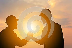 Silhouette of Business engineer man with clipping path handshake evening sky sunset background, Success and happiness team concept