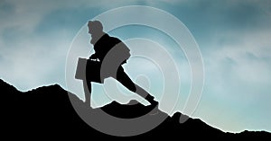 Silhouette business person walking on mountain against sky