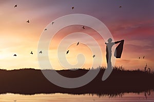 Silhouette of businessman enjoying sun shining with flying birds