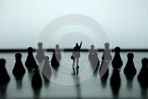 Silhouette of businessman pointing upside in the middle of chess piece