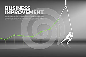 Silhouette of businessman pull up the business graph with rope and reel.