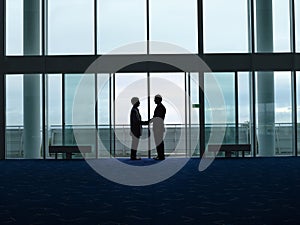 Silhouette Businessmen Shaking Hands At Airport