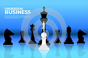 Silhouette of businesswomen standing on white pawn chess piece in front of all of black chess piece.