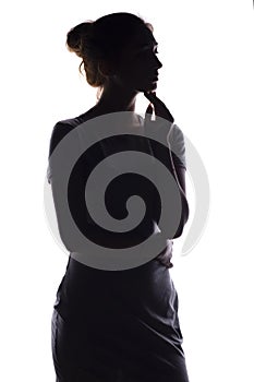 Silhouette of a calm young woman on a white isolated background, figure of slim pensive girl
