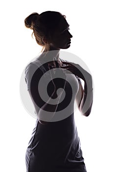 Silhouette of a calm young woman on a white isolated background, figure of slim pensive girl