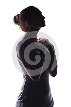 Silhouette of a calm young woman on a white isolated background, figure of slim pensive girl