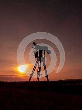 Silhouette of a camera and tripod against a beautiful sunset