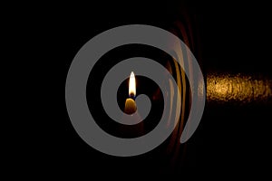 A silhouette of a candelabra with a burning candle