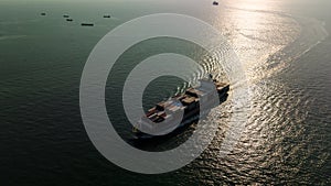 silhouette cargo container ship sailing in sea to import export goods and distributing products to dealer and consumers worldwide