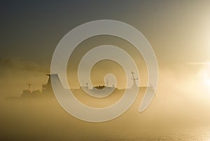 Silhouette of the cargo ship over the sunrise