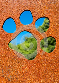 Silhouette of a cat paw in rusty metal wall