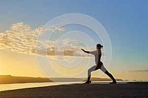 silhouette of Caucasian woman making a posture of the yoga warrior