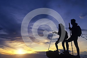 Silhouette of a champion couple on the top of a rock mountain vi