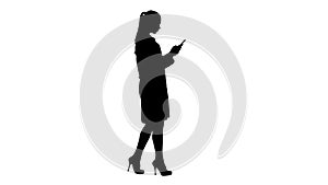 Silhouette Cheerful cute young woman doctor typing text on phone while walking.