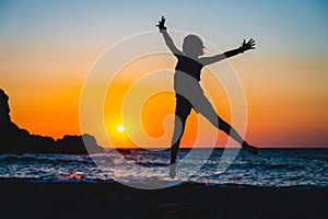 Silhouette of a child jumping in sunset on a beach