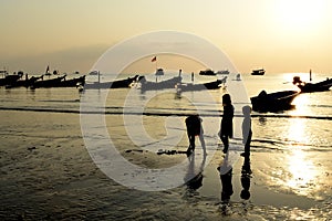 Silhouette child plaing on sunset beach kho tao island thailand