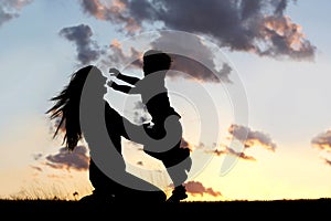 Silhouette of Child Running to Hug Mother at Sunset