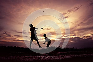 Silhouette of children playing paper airplane at sunset