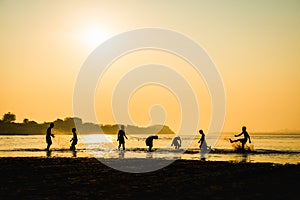 Silhouette of children playing water with friend