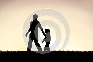 Silhouette of Christian Father Guiding his Young Child by the Hand photo
