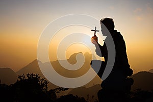 Silhouette of christian man hand praying, man holding a crucifix praying, spirituality and religion, woman praying to god.