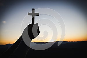 Silhouette of christian woman hand praying, woman holding a crucifix praying, spirituality and religion, woman praying to god.