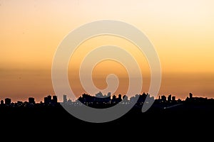 Silhouette of cityscaper buildings during a sunset