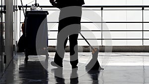 Silhouette of cleaning service people sweeping floor