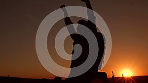 Silhouette of climber with backpack at sunset.