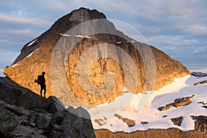 Silhouette of a climber in front of a mountain wall