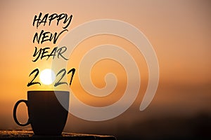 Silhouette coffee cup with happy new year 2021 text on a sunrise background